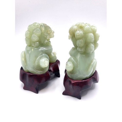 123 - A pair of Jadeite Chinese Dragon Dogs on wooden stands in good condition. 7cm 328gms excluding stand... 