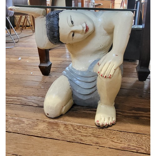 32 - A carved wooden 'Asian Figure' coffee table with circular glass top. 50cm x 50cm diameter