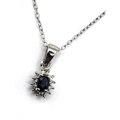 400 - A silver pendant set with an oval natural sapphire surrounded by white clear stones on silver chain ... 