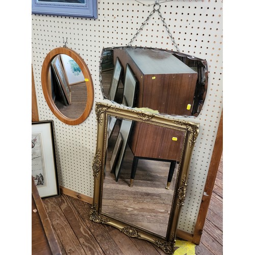 38 - Three mirrors: a 1950's scalloped edge mirror, a beveled mirror in a gilt frame, and an oval pine fr... 