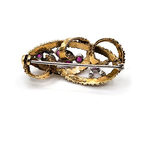 408 - A yellow and white gold twisted knot brooch set with round brilliant diamonds and six rubies. 6.8gms... 