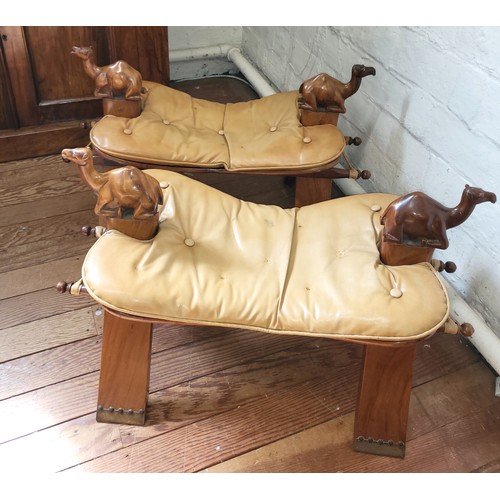 53 - Two camel saddle stools circa 1930's. Each stool has a carved wooden camel at each end, padded butto... 