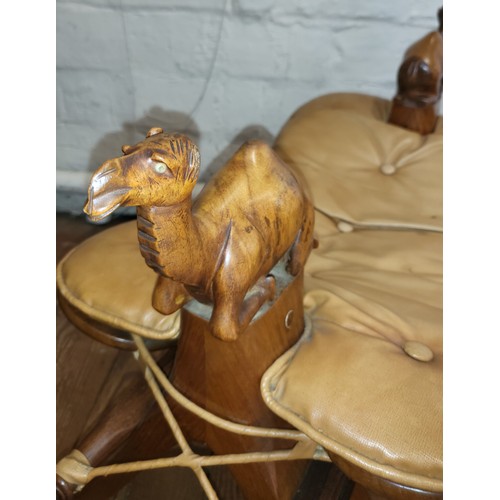 53 - Two camel saddle stools circa 1930's. Each stool has a carved wooden camel at each end, padded butto... 