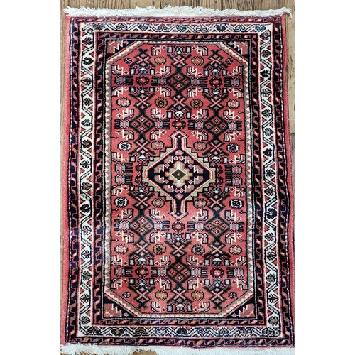 80 - A pink, blue and white patterned rug.
95cm x 62cm.