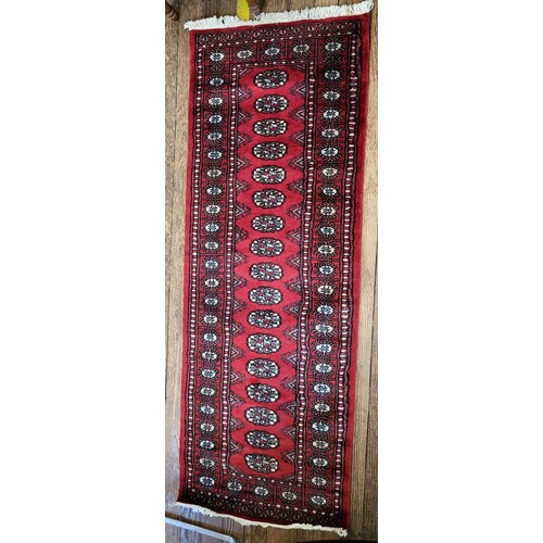 85 - A red ground rug 185cm x 68cm