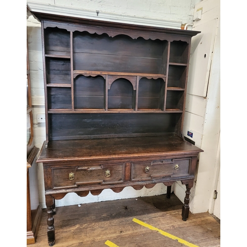 57 - A dresser with scalloped frieze over several shelves and a base with two drawers standing on turned ... 