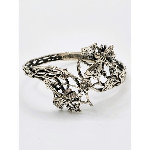 415 - A silver Art Nouveau style bangle with ivy leaf and dragonflies 37.8gms