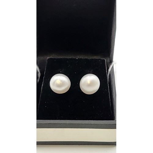 416 - A pair of freshwater pearls earrings with silver mounts. 10mm diameter