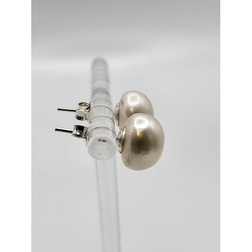 416 - A pair of freshwater pearls earrings with silver mounts. 10mm diameter