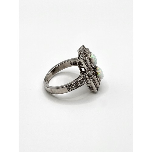 419 - A silver cubic zirconia and faux opal panelled ring in the Art Deco style. Size R 8.3gms