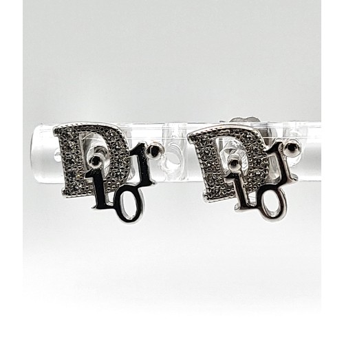 420 - A pair of silver and cubic zirconia designer style stud earrings. 1.2gms.