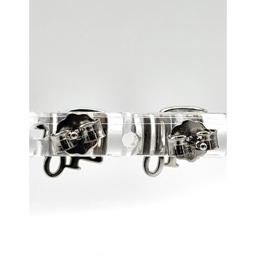 420 - A pair of silver and cubic zirconia designer style stud earrings. 1.2gms.