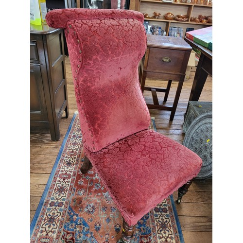 66 - An upholstered prayer chair, stud trim on the base of the chair, turned front legs, tapered back leg... 