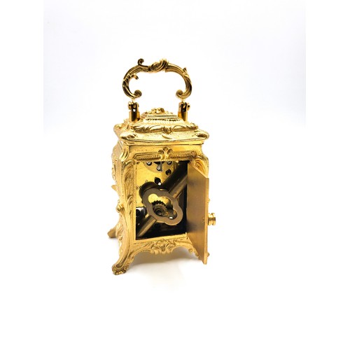 60 - An antique style Rococo cased miniature carriage clock with key. 10cm (including handle)