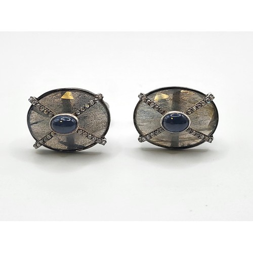 379 - A pair of large oval cufflinks set with labradorite, sapphires, and diamonds, in white metal, boxed.... 