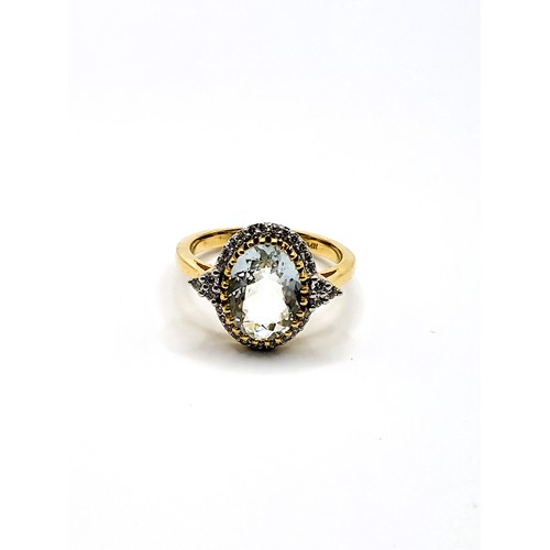 380 - A stamped 14ct yellow gold oval aquamarine and round cut diamond set cluster ring with diamond shoul... 