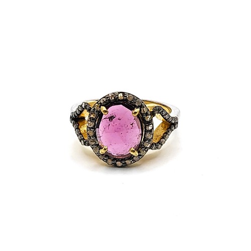 382 - A gilt ring set with an oval chequer board cut  rhodolite garnet and diamond halo, with diamond shou... 