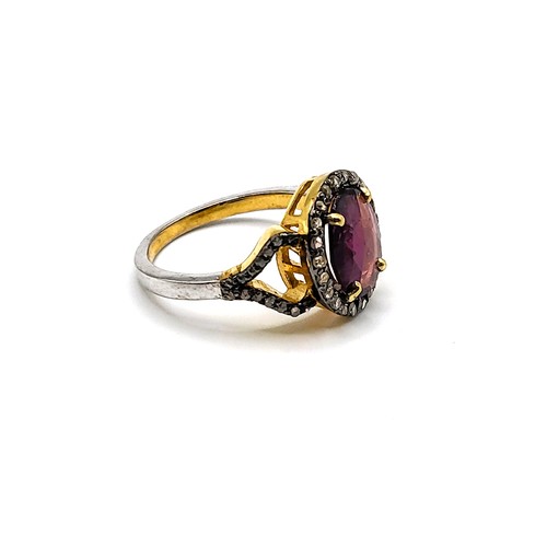 382 - A gilt ring set with an oval chequer board cut  rhodolite garnet and diamond halo, with diamond shou... 