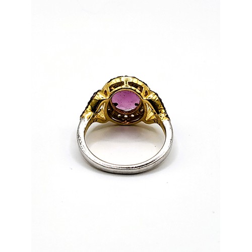 382 - A gilt ring set with an oval chequer board cut  rhodolite garnet and diamond halo, with diamond shou... 