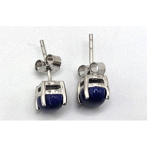 386 - A pair of oval cabochon lapis lazuli studs in silver stamped 925 on the post and butterfly. 1.9gms