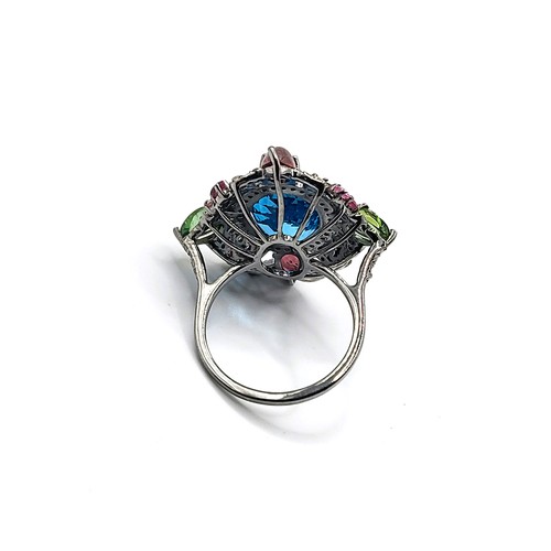 388 - A large dress ring set with an oval-cut Swiss blue topaz, pear-cabochon pink and green tourmalines, ... 