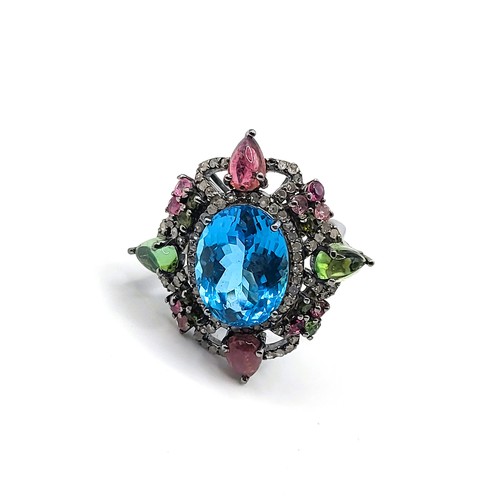 388 - A large dress ring set with an oval-cut Swiss blue topaz, pear-cabochon pink and green tourmalines, ... 