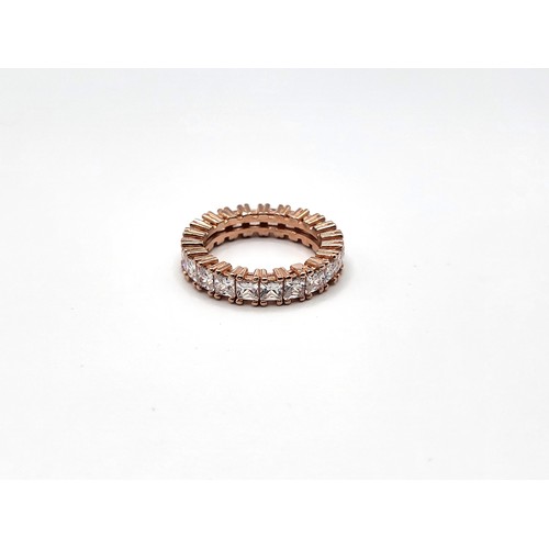 392 - A rose gold-plated silver stamped S 925, princess cut cubic zirconia full eternity ring. 4.8gms Size... 