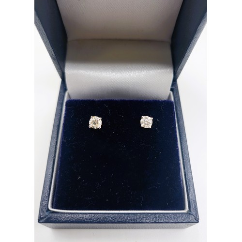 396 - A pair of 14ct white gold diamond stud earrings of 38 points. 0.5gms