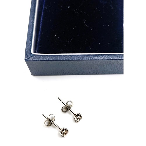 396 - A pair of 14ct white gold diamond stud earrings of 38 points. 0.5gms