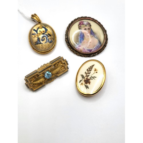 412 - A Victorian glass top pendant/ memento mori locket in gilt metal, and three brooches including a ova... 