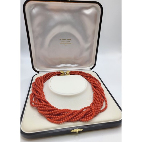 416 - A multi-strand orange-red glass beaded choker necklace with an 18ct twist clasp and leaf motif caps ... 