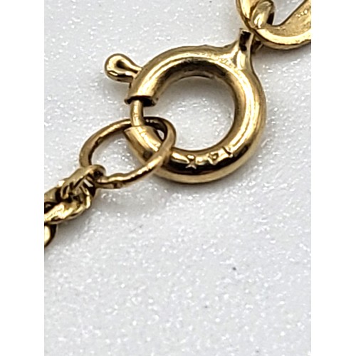 423 - A 14ct yellow gold diamond cut  rope chain bracelet with a pair of babies booties (14ct).  2gms 18cm... 