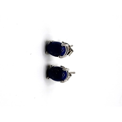 386 - A pair of oval cabochon lapis lazuli studs in silver stamped 925 on the post and butterfly. 1.9gms