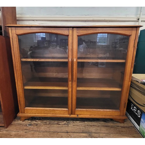 14 - An oak glass front bookcase with two shelves. 104cm x 122cm x 38cm.