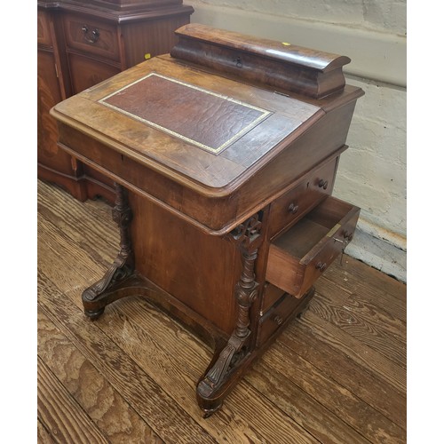 21 - A walnut davenport with four drawers and a key. The sloping top has red leather inlay writing surfac... 