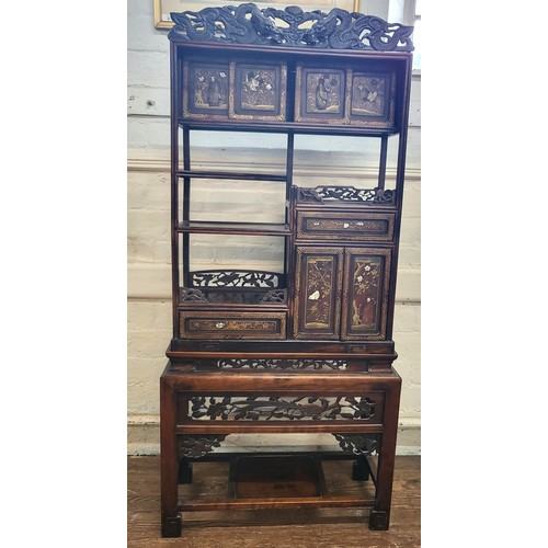 22 - A Chinese ornately carved and decorated display unit. 168cm x 71cm x 25cm.