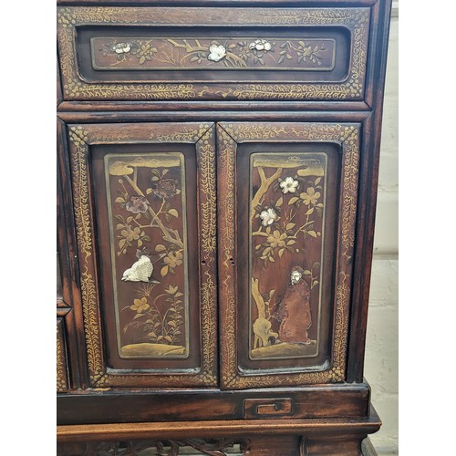 22 - A Chinese ornately carved and decorated display unit. 168cm x 71cm x 25cm.