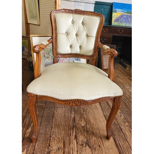 24 - A button back chair upholstered in cream fabric, wooden arms, overstuffed seat over cabriole legs.