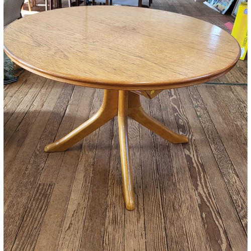 25 - An oak extending kitchen table on a four footed pedestal. 72cm x 108cm.