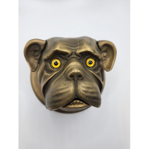 46 - An unusual bronze dog's headed bell (depress ears) with glass bead eyes. 11.5cm diameter.  988gms.