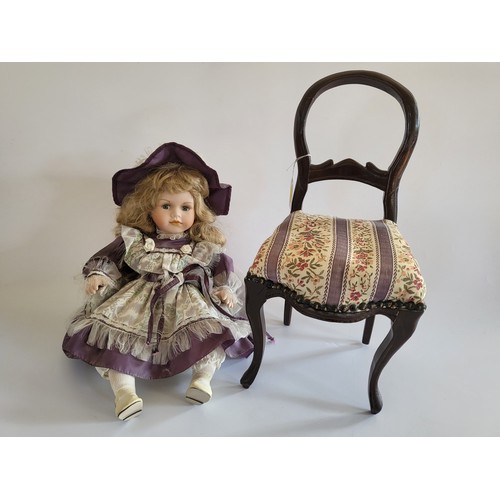 192 - A Leonardo collection bisque headed doll on a reproduction Edwardian balloon back chair (2)