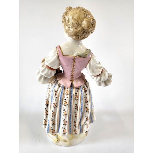 216 - A late Meissen porcelain figure of a girl with basket of bunches of grapes and sickle. 14cm