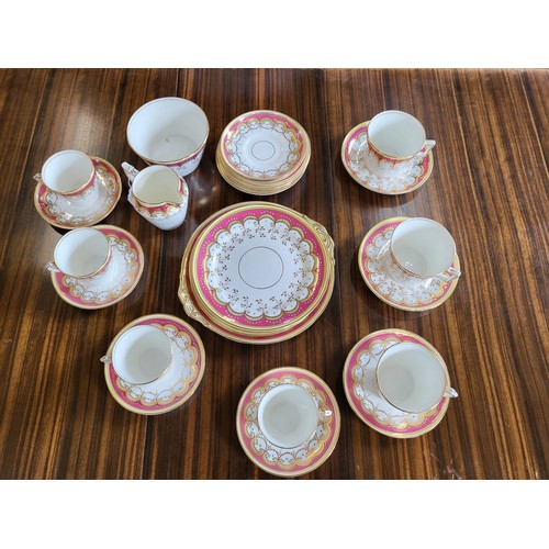 241 - A porcelain part tea-set with pink, cream and gilt border pattern. (28)