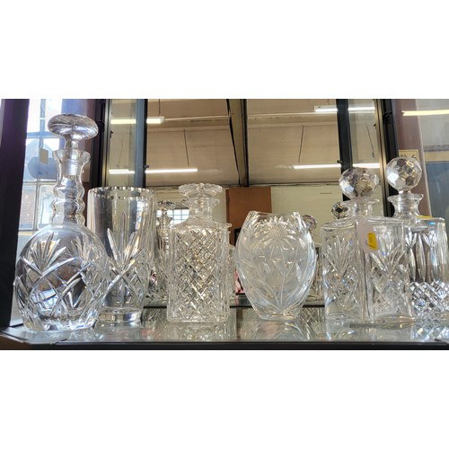 243 - Four cut glass decanters with stoppers, 21cm to 29cm, and two vases 17cm and 20cm. (6)