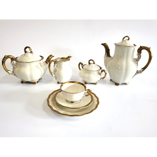 250 - A German Koenigszelt porcelain Charlotte tea and coffee service in cream with gilt borders. (37)