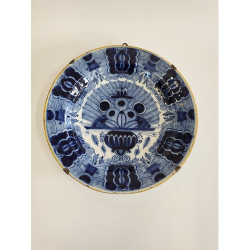 255 - A Delft-style dish in blue and white with ochre rim. 35cm.