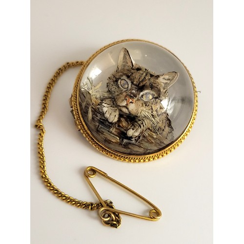 312 - An Essex Rock crystal brooch. Reverse carved and painted of a tabby cat in a basket. Set in a yellow... 