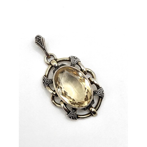 313 - An oval citrine pendant in white and yellow metal (stamped 935 on the bale) 3.5cm x 2cm, and a match... 