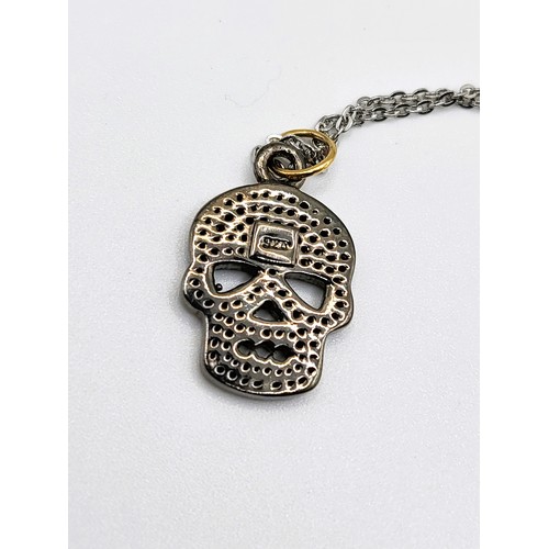 346 - A diamond set skull pendant in silver and silver gilt, on a silver chain 46cm, boxed. Diamonds 0.40c... 