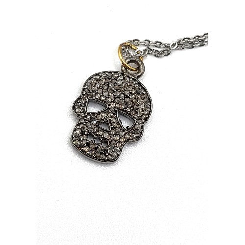 346 - A diamond set skull pendant in silver and silver gilt, on a silver chain 46cm, boxed. Diamonds 0.40c... 